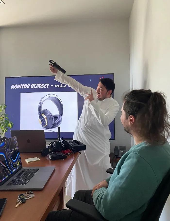 Jemeel pointing to a monitor while reviewing footage with a colleague